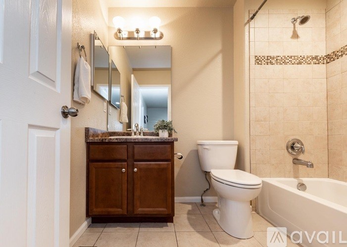 A bathroom with a white toilet, a wooden cabinet, and a bathtub.