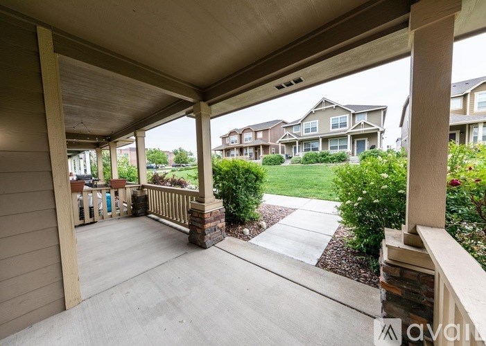 A covered patio area with a concrete floor and pillars.