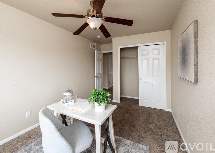 A room with a table, chairs, and a ceiling fan.