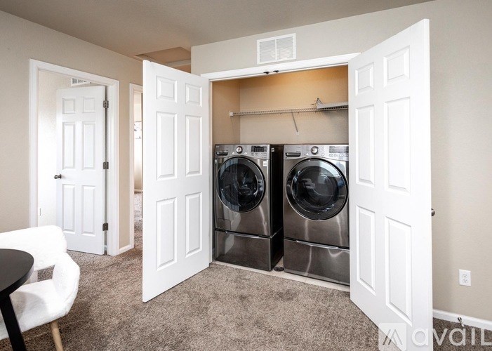 A laundry room with two washing machines and a white door.