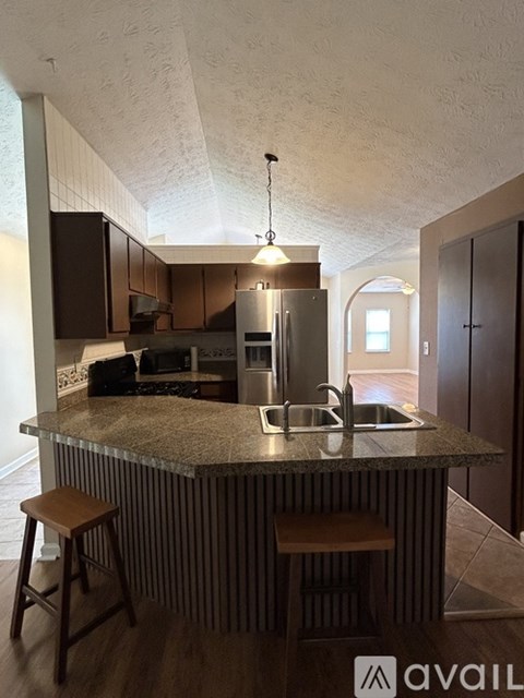 A kitchen with a bar stool and a counter.