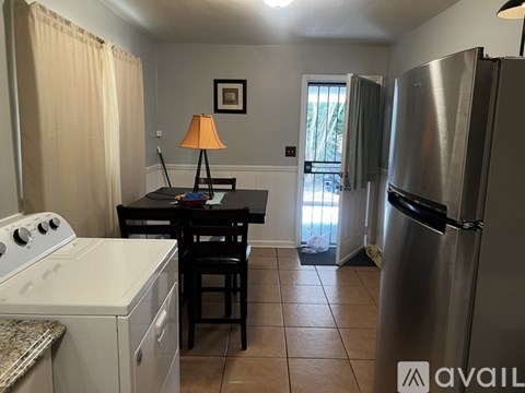 A kitchen with a stove, table and chairs.