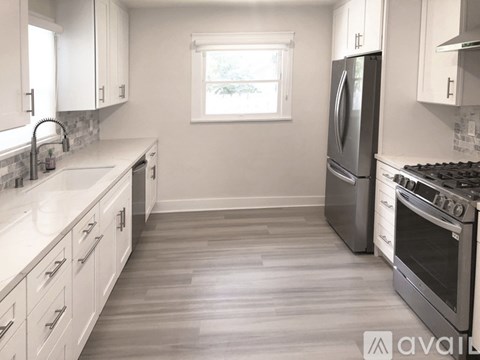 A kitchen with white cabinets and a window.