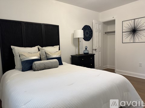 A bedroom with a large bed and a black dresser.