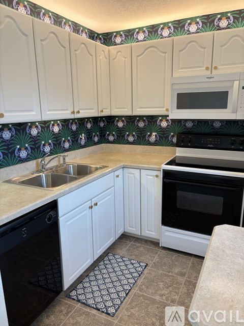 A kitchen with white cabinets and a black oven.