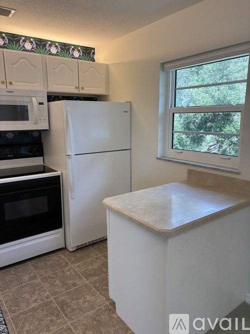 A kitchen with a white refrigerator, microwave, and oven.
