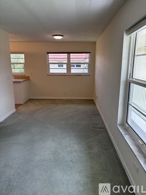 A room with a carpeted floor and a window with blinds.