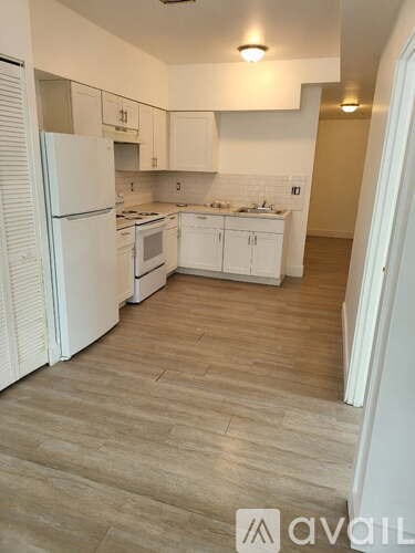 A kitchen with white appliances and cabinets.
