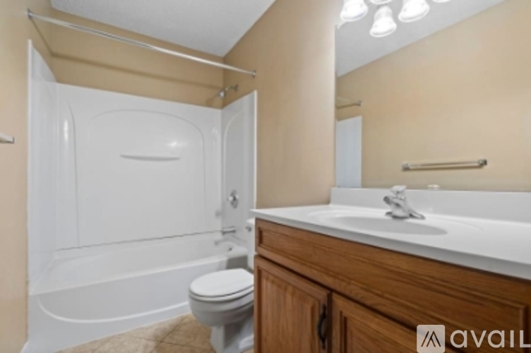 A bathroom with a white tub, toilet, and sink.