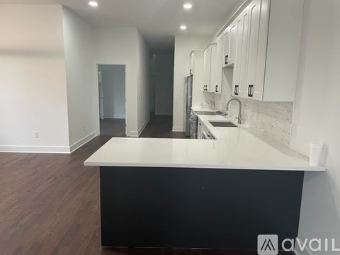 A kitchen with a black counter and white cabinets.