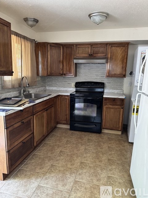 A kitchen with wooden cabinets and a black oven.