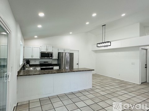 A kitchen with white cabinets and a tiled floor.