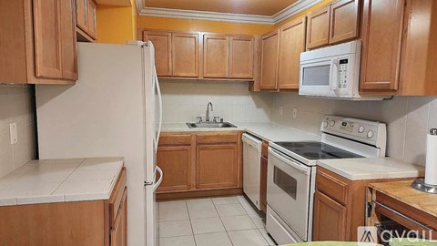 A kitchen with wooden cabinets and white appliances.