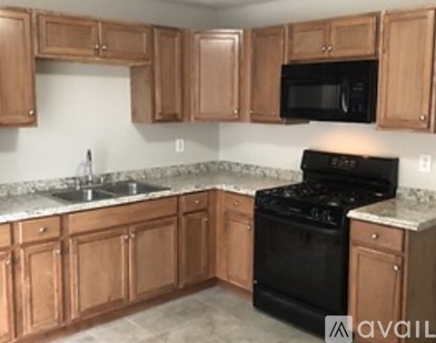 A kitchen with wooden cabinets and a black stove.