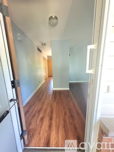A hallway with wood floors and white walls.