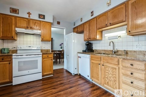 A kitchen with wooden cabinets and a white dishwasher.