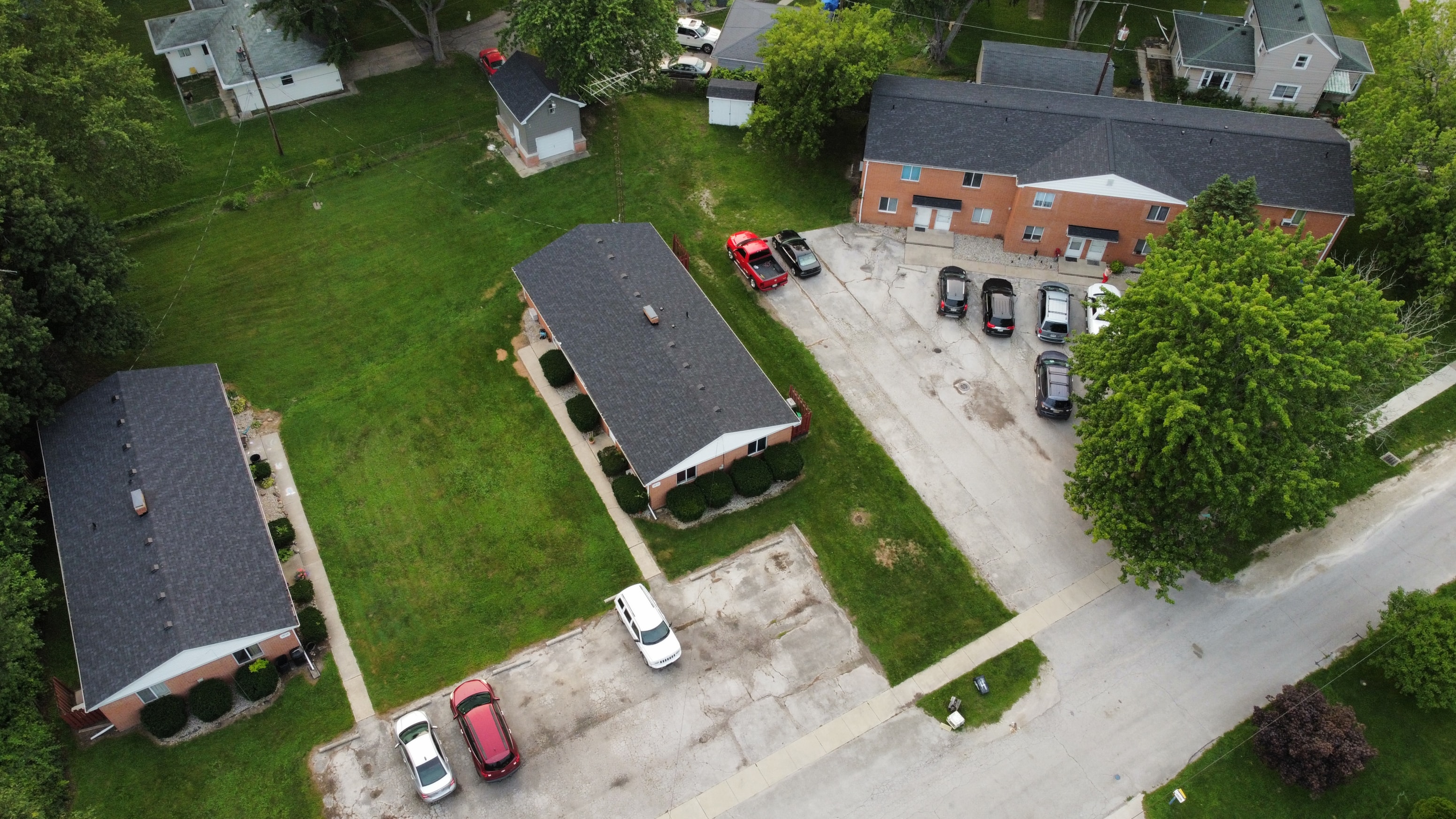 A parking lot with cars and a building in the background.