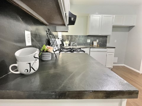A kitchen counter with a white mug that has the letter K on it.