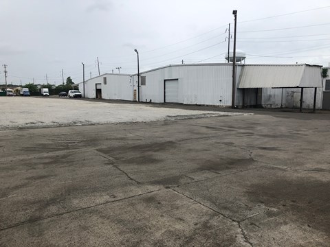 A large, empty parking lot with a white building in the background.