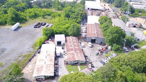 An aerial view of a parking lot with several cars and buildings.
