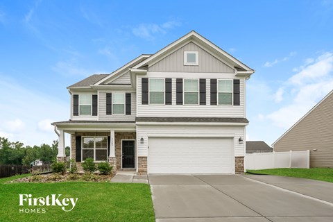 A house with a garage and a driveway in front of it.