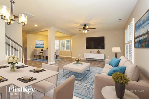 A well-lit, spacious living room with a dining table set for six.