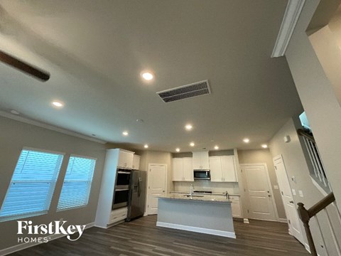 A spacious kitchen with a refrigerator, sink, and cabinets.
