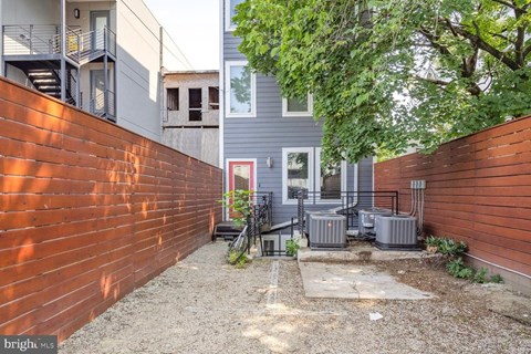 A backyard with a wooden fence and a bicycle leaning against it.