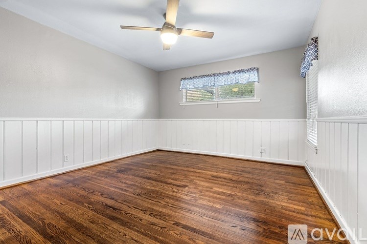A room with wooden flooring and a ceiling fan.