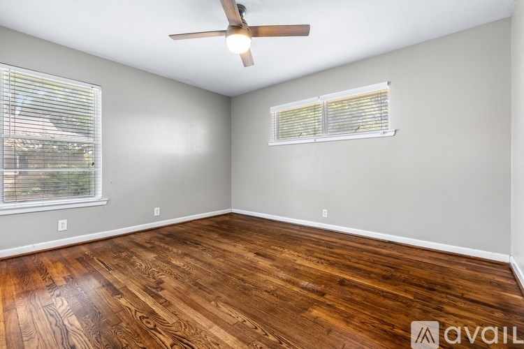 A room with wooden flooring and a ceiling fan.