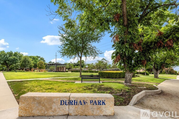 A stone sign that says Durham Park is in front of a park.