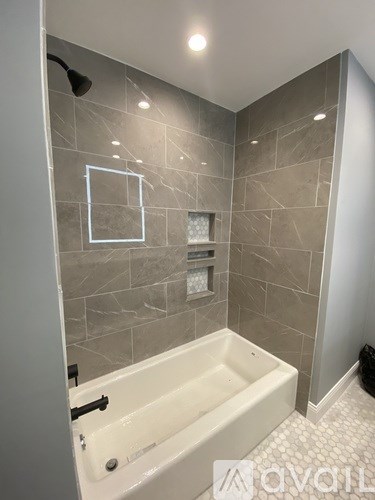 A bathroom with a tub and a shower.