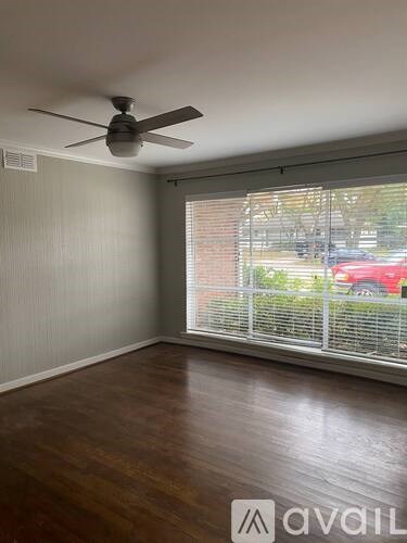 A room with a ceiling fan and a window with blinds.