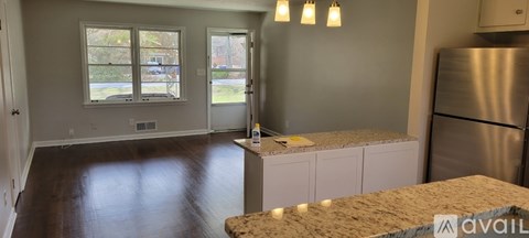A kitchen with a refrigerator and a countertop with a sink.