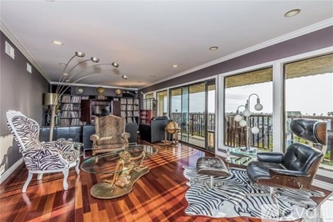 A living room with a zebra print rug and a glass coffee table.