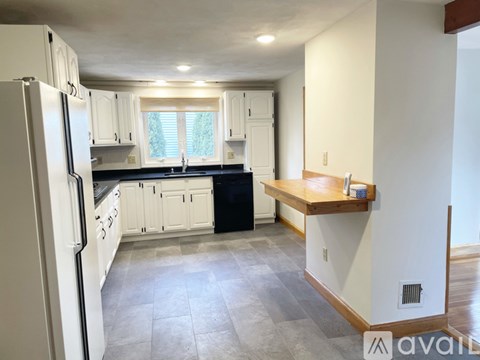 A kitchen with white cabinets and a black dishwasher.