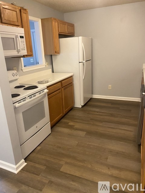 A kitchen with a white fridge and stove top oven.