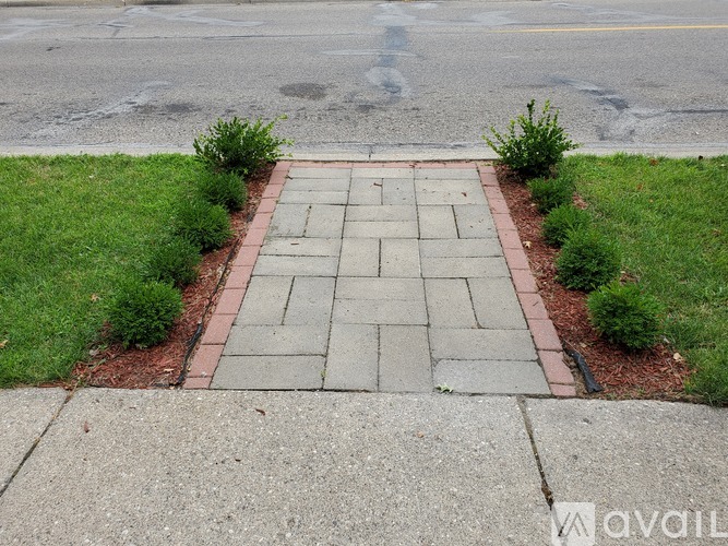 A brick pathway leads to a grassy area.