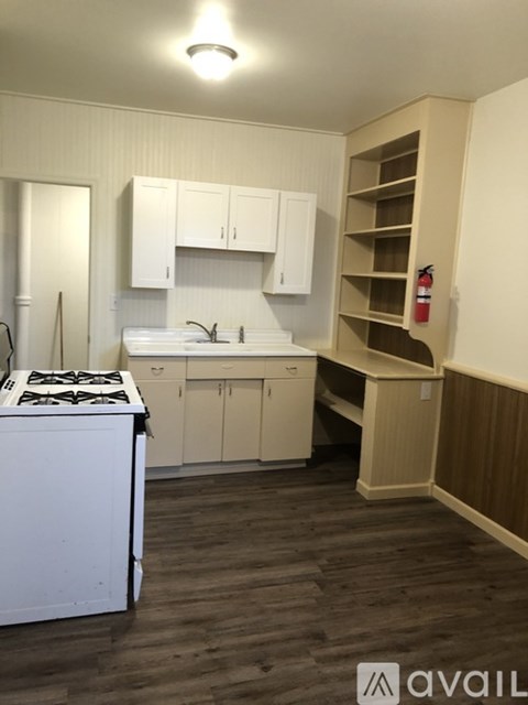 A kitchen with white cabinets and a stove top oven.