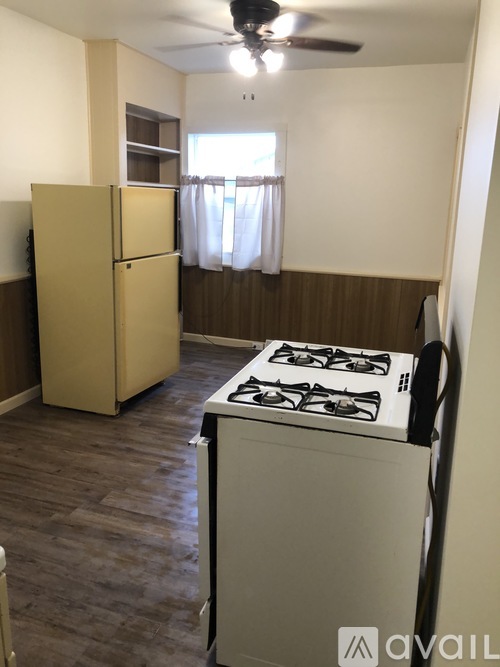 A kitchen with a stove and a refrigerator.