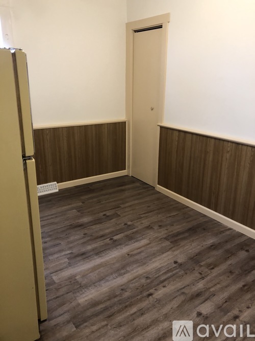 A room with a wooden floor and a white door.