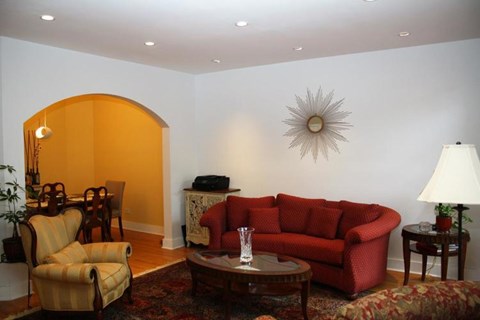 A living room with a red couch and a yellow chair.
