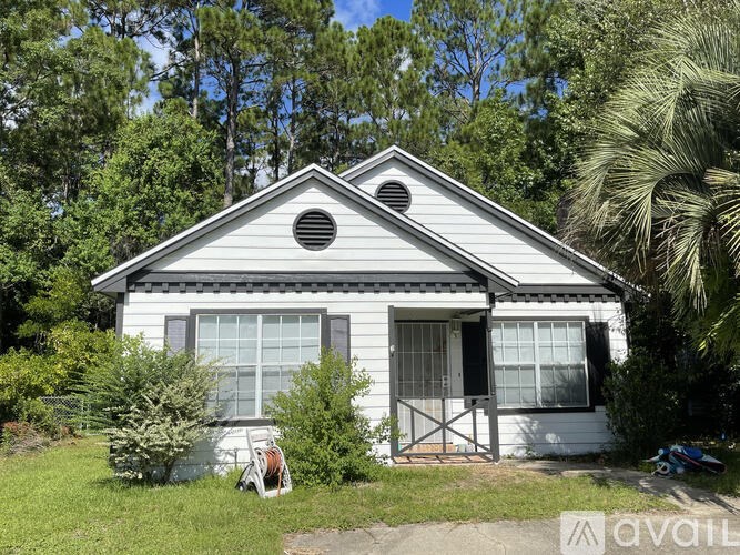 A small white house with a black roof and a small porch.