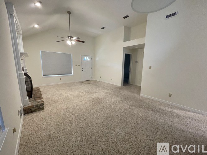 A spacious room with a ceiling fan and a whiteboard on the wall.