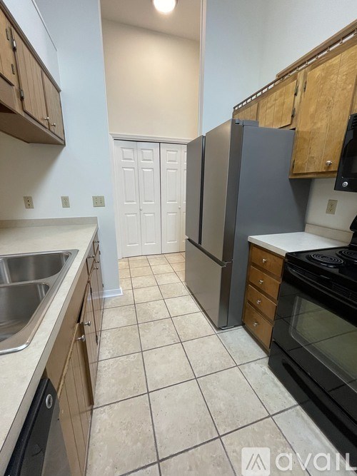 A kitchen with a white tile floor and a white door in the background.