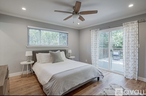A bedroom with a large bed and a ceiling fan.