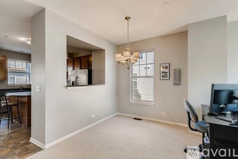 A living room with a television and a desk with a chair.