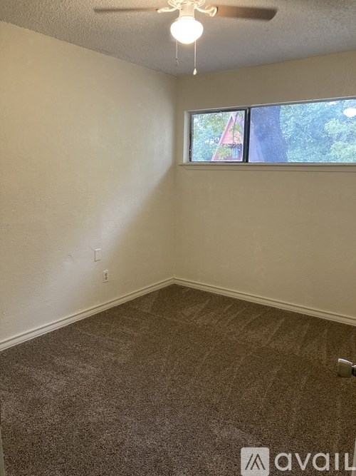 A room with a carpeted floor and a window.