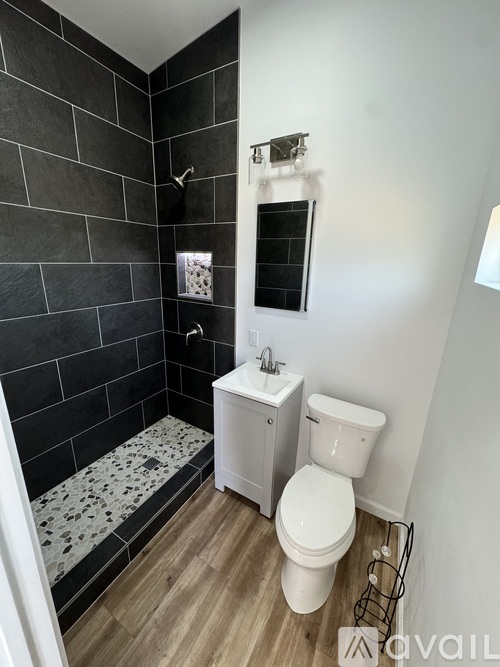 A bathroom with a toilet, sink, and shower.