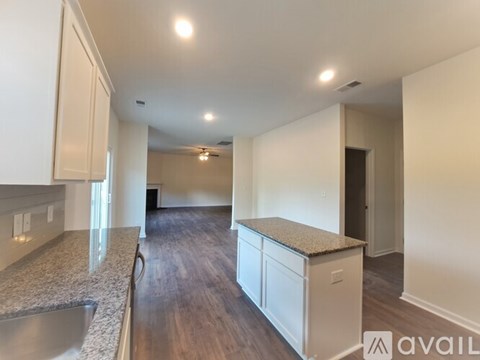 A kitchen with white cabinets and a granite countertop.